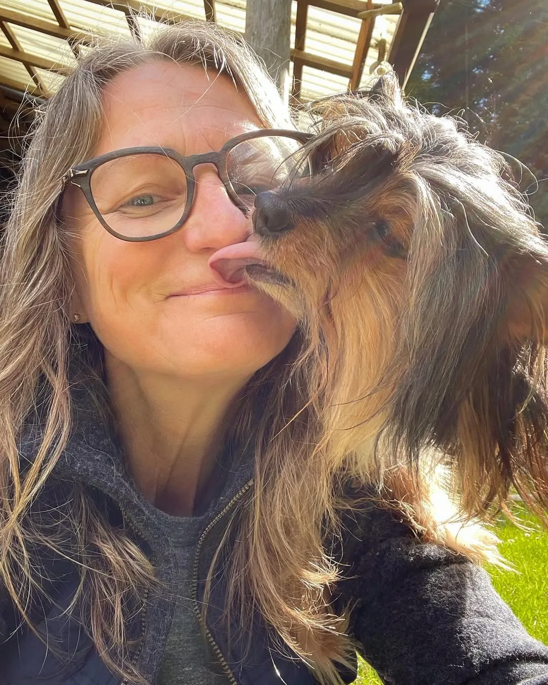 Dawn Thomas getting a kiss from her dog in the sunshine
